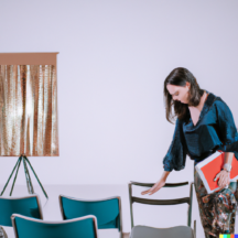 Gli eventi: come progettarli e realizzarli- photo of a designer woman who plans an event with a folder in his hand and a room set up with chairs and a stage in front of him